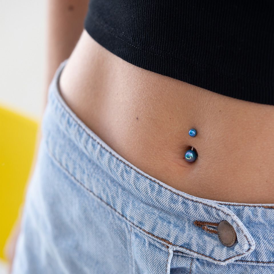 Navelpiercing met metallic balletjes