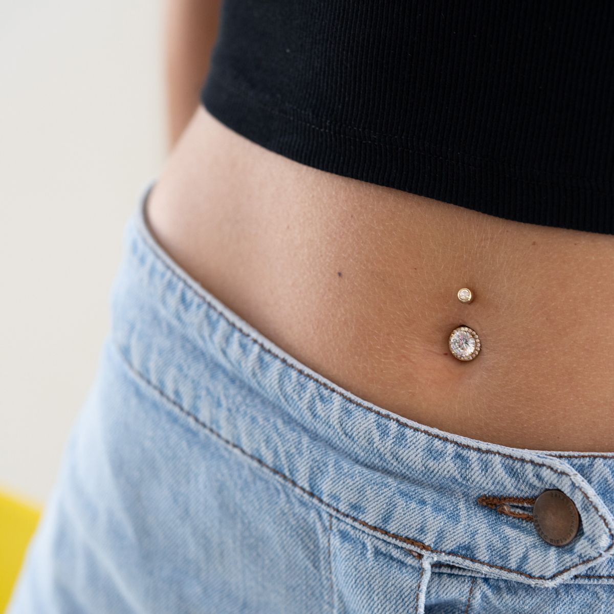 Navelpiercing met grote, fonkelende steen met vele vlakken