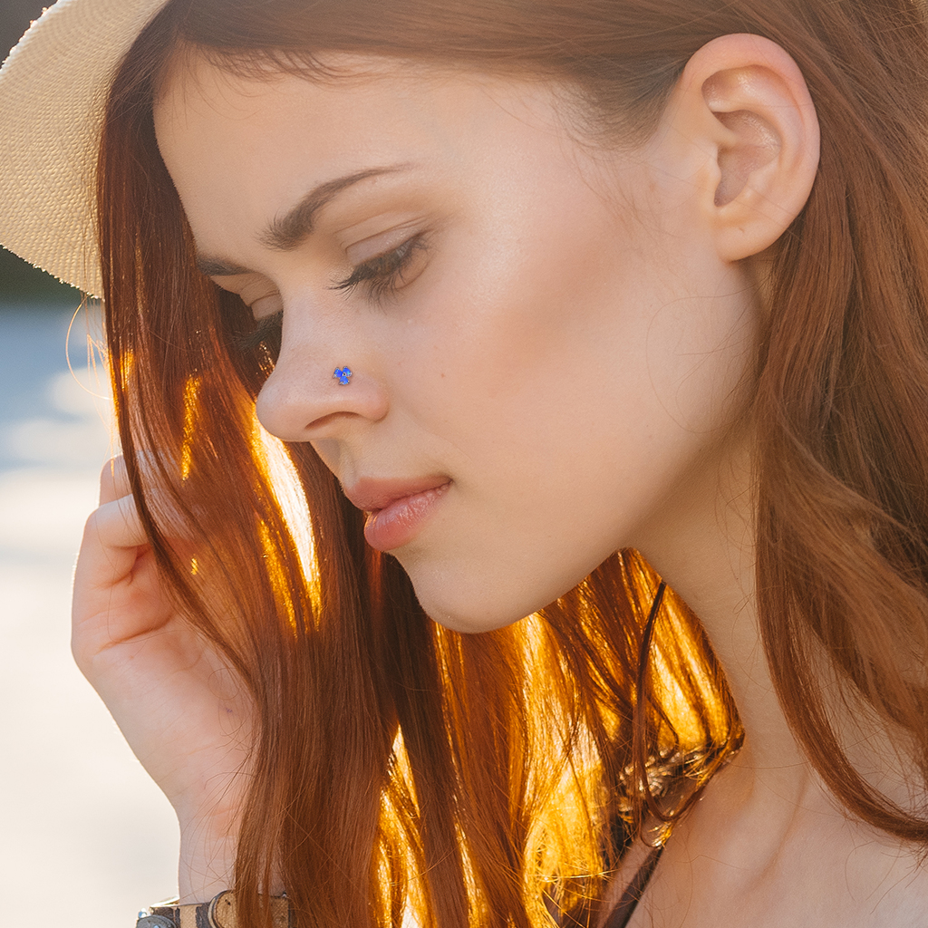 Neuspiercing van 14 karaats goud met drie opaalsteentjes